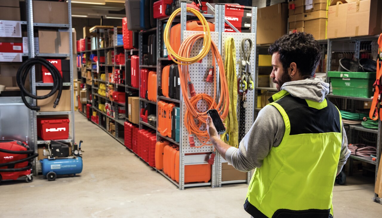 hilti darbinieks meklē instrumentus savā tālrunī