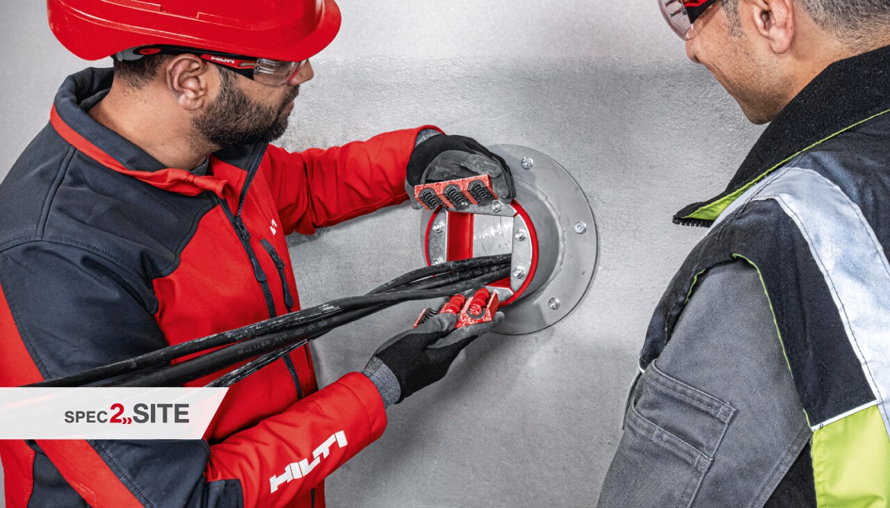 Hilti lauka inženieris demonstrē klientam ugunsdrošības uzmavu elektroinstalācijas pielietojumā.