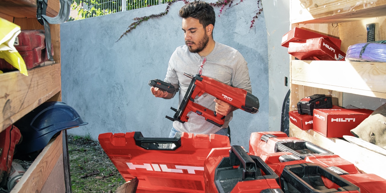 Persona, kas pārbauda savu darbarīku noliktavu, kura ir pilna ar hilti instrumentiem